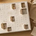 Calendrier de l'avent 2022 bijoux : accessoires dorés et argentés sur fond bois clair