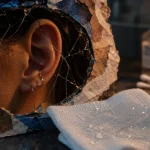 Chéloide piercing : boule rouge près d’un trou d’oreille après piercing