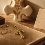 Croix religieuse : croix de baptême en or jaune sur velours beige