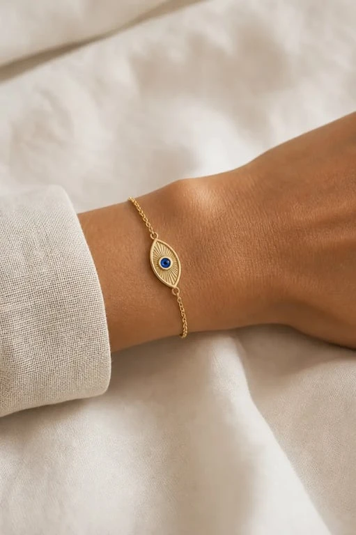 Bracelet oeil doré avec motif œil bleu porté au poignet