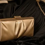 Pochette or champagne sur velours noir, gros plan